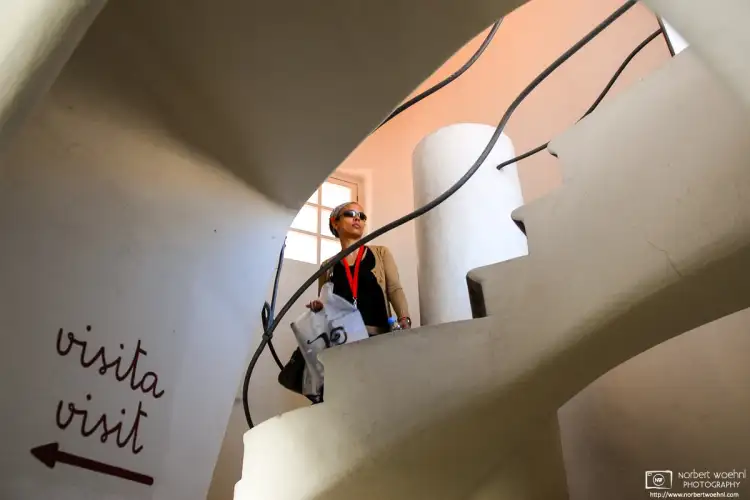 A visitor walking on a spiral staircase inside Casa Batlló, Antoni Gaudí’s architectural masterpiece in Barcelona, Spain.