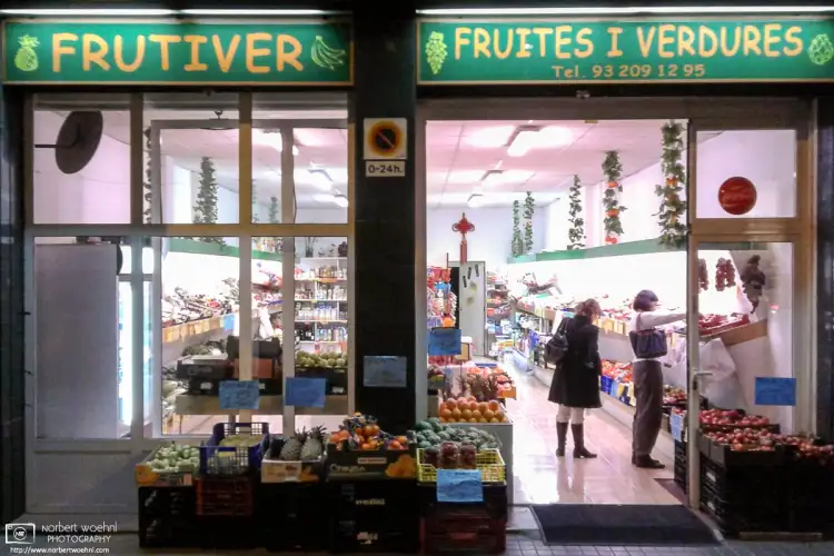 Late shoppers at a greengrocers in the Sant Gervasi – Galvany neighborhood of Barcelona, Spain.