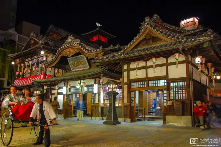 An evening scene outside Dōgo Onsen Honkan, the main public bathhouse at the Dogo Onsen Hot Spring in Matsuyama, Japan.