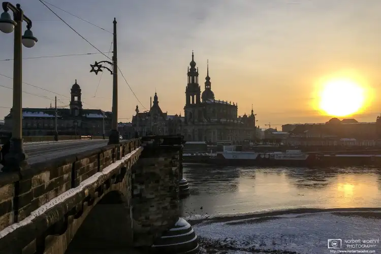 A winter view of Augustus Bridge spanning the Elbe River into the historic city center of Dresden, Germany.