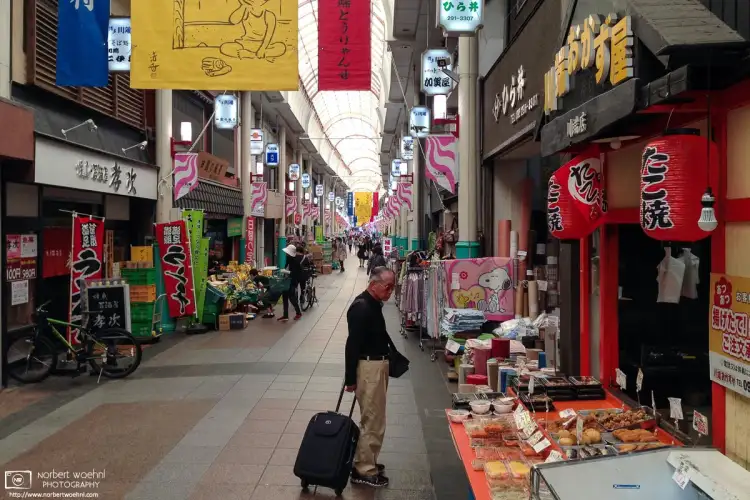 A gentleman exploring lunch options at a shop inside Kawabatadori Shopping Street in Fukuoka, Japan.