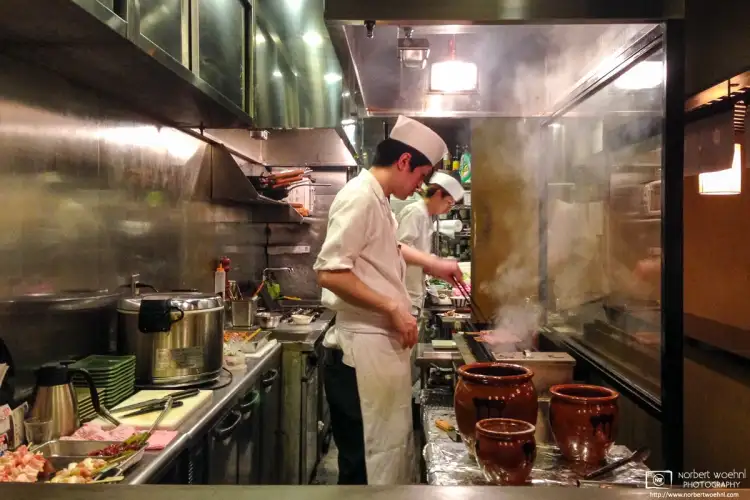 Watching the kitchen staff at work at a Yakitori (skewered grilled chicken) restaurant in Fukuoka, Japan.
