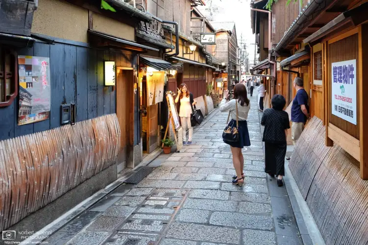 A delightful scene of visitors snapping photos in a side street of the Gion district in Kyoto, Japan.