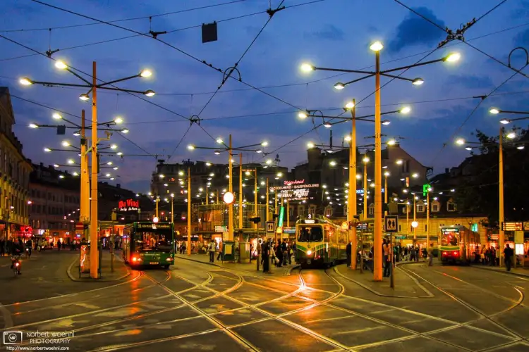 A dusk scene from Jakominiplatz in Graz, Austria, one of the citys main transportation hubs at which multiple tram and bus lines intersect.
