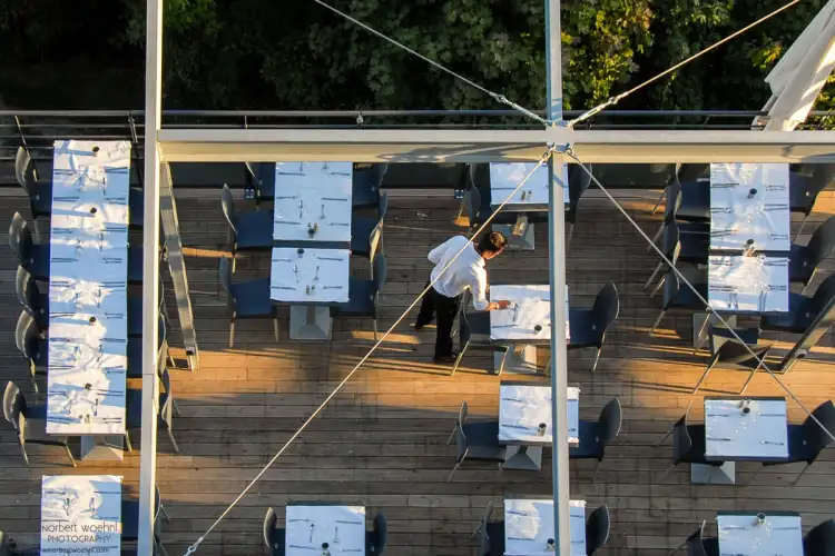 At a restaurant on La Bastille in Grenoble, France, tables are being set for the evening’s guests.