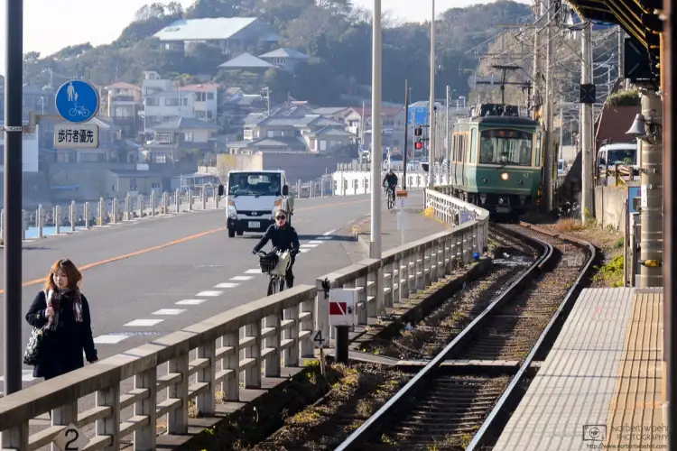 An Enoshima Electric Railway Train arrives at the ocean-side Kamakurakokomae Station in Kamakura, Japan.