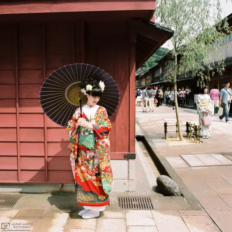 On a walk through the historic district of Kanazawa, Japan, I managed to take this photo of a young woman in kimono posing in this classic Japanese setting.
