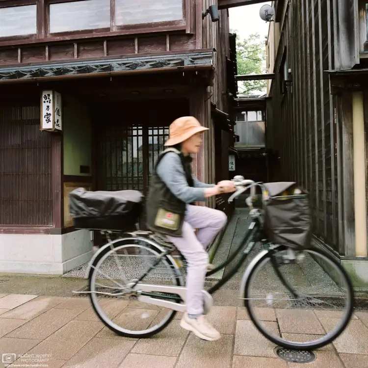 A woman rides her bicycle in Kazue-machi Chayagai, a small district of preserved teahouses in Kanazawa, Japan.