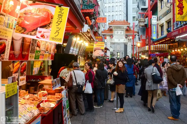 A foodie pictured amidst a variety of food choices in the Chinatown of Kobe, Japan.