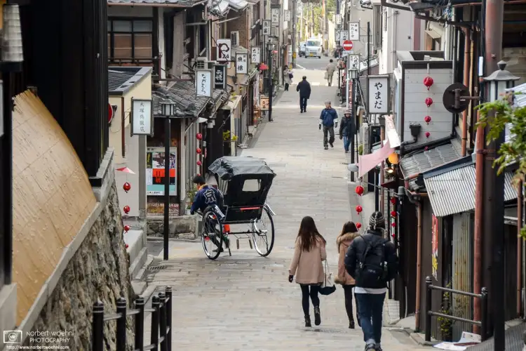 A jinricksha driver making a turn into a side street in the Higashiyama area of Kyoto, Japan.
