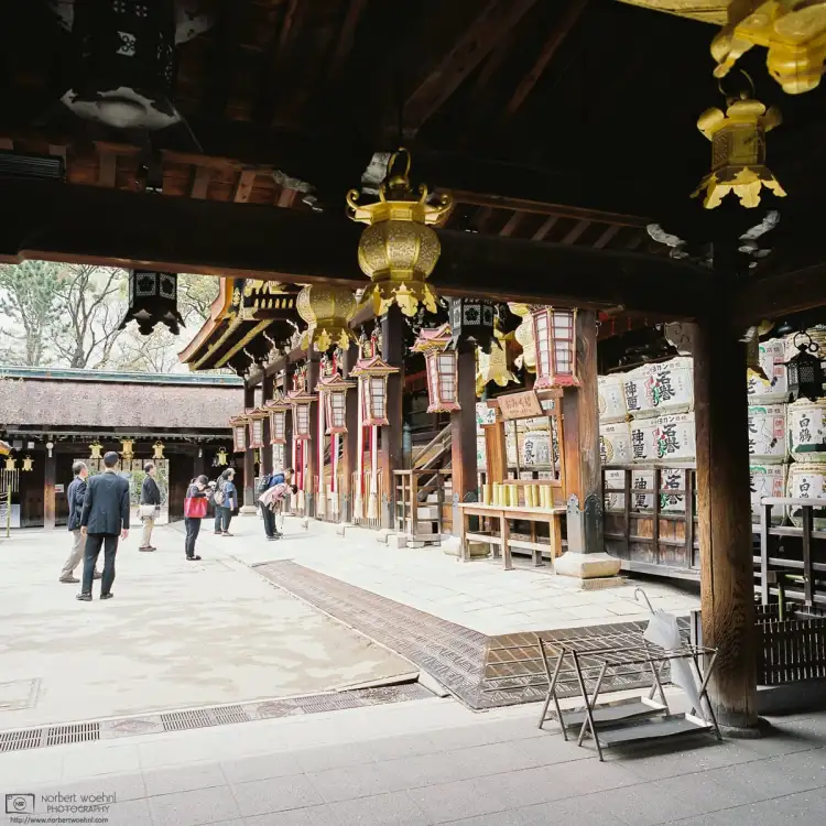 Visitors arriving for prayer at the Main Hall of Kitano Tenmangū Shrine in Kyoto, Japan.