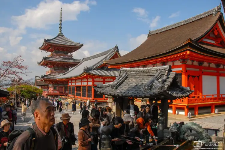 Visitors arriving at the main entrance of the iconic Kiyomizudera Temple in Kyoto, Japan.