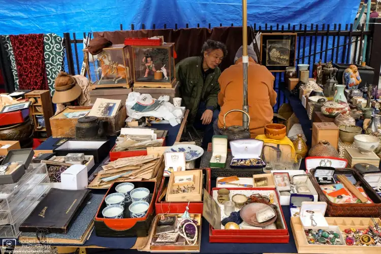 Flea market vendors are having a chat amidst their colorful merchandise at Tōji Temple in Kyoto, Japan.