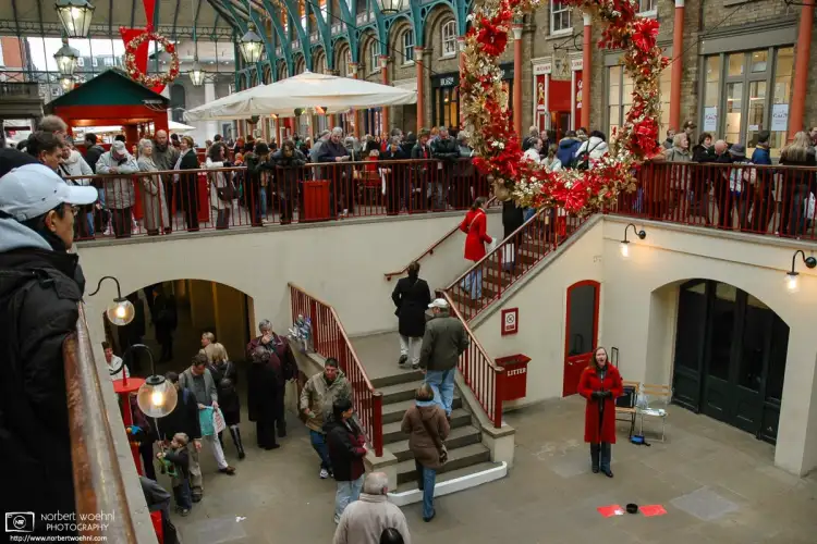 A woman is singing Christmas songs at Covent Garden in London, England.