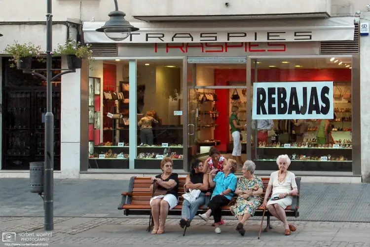 Ladies enjoying a summer afternoon chat in a quiet residential and shopping area of Madrid, Spain.