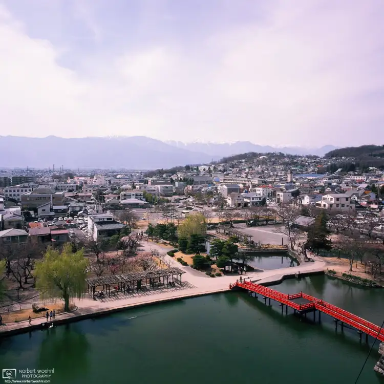 A splendid view through a small window at the top of Matsumoto Castle in Matsumoto, Nagano Prefecture, Japan, with the Japanese Alps visible in the back.