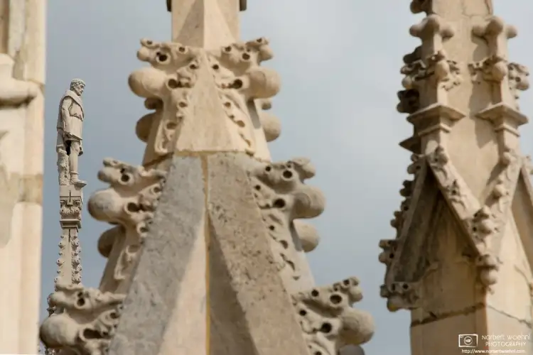 A statue on top of one of the rooftop spires at the Duomo, the glorious cathedral of Milan, Italy.