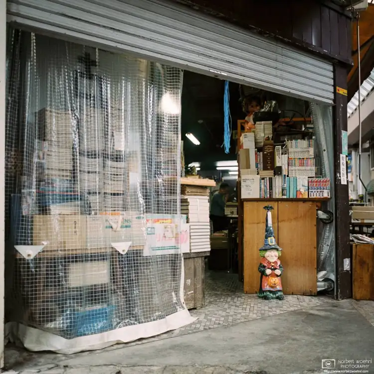 A friendly figure is standing beside a bookshelf at an antiques shop inside Gondo shopping street, Nagano, Japan.