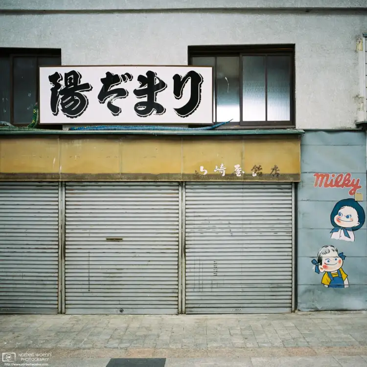 At Gondo Shopping Street in Nagano, Japan, an advertisement mural is painted on the wall beside an old shop.