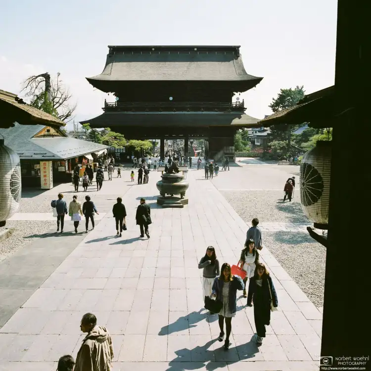 Visitors arriving at the main hall of Zenkōji Temple in Nagano, Japan. This photo looks south towards the Sanmon Gate.