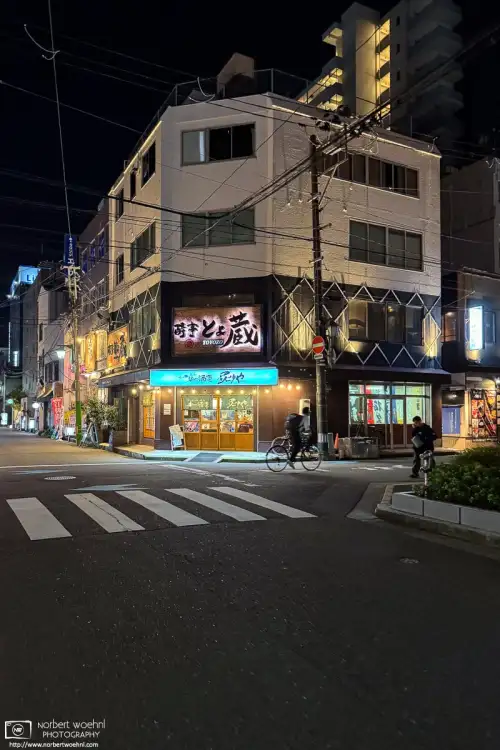 Evening photo of an intersection with various pubs in the area northeast of Niigata Station in Niigata, Japan.