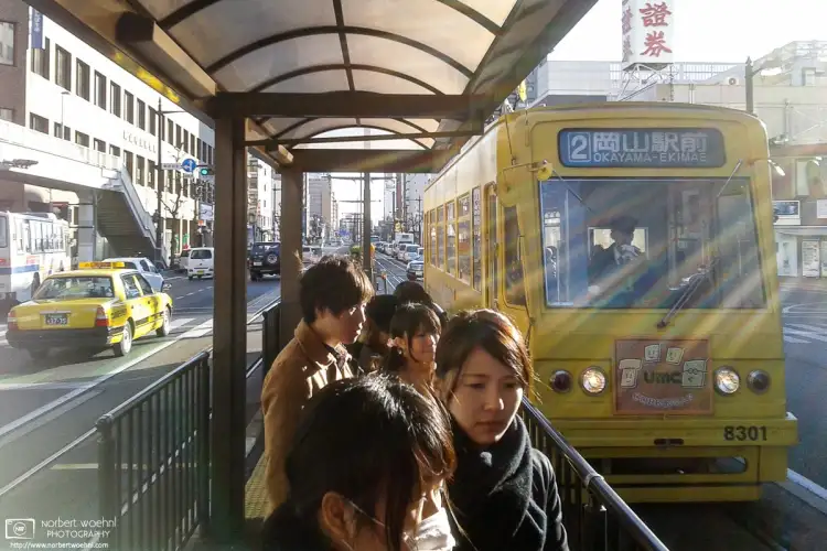 A streetcar arrives at Yūbinkyokumae Station in Okayama, Japan.