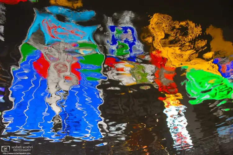 Colorful neon advertisement signs are reflected off the surface of the Dotonbori Canal in Osaka, Japan.