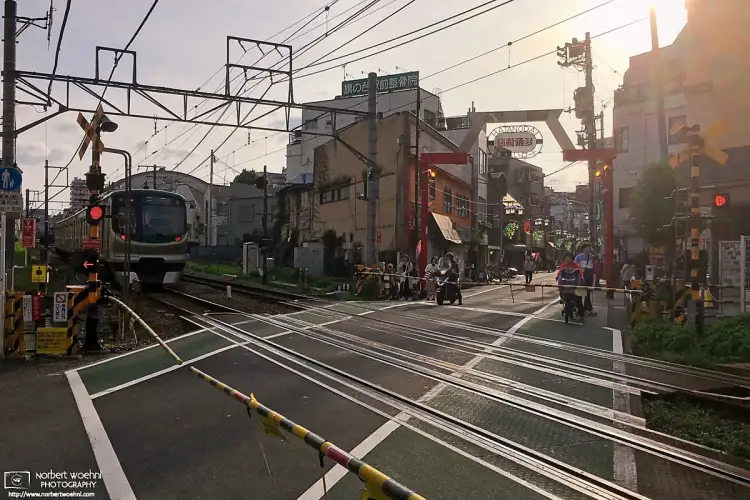 Afternoon scene at a typical street-level railway crossing in the Hatanodai area of Shinagawa Ward in Tokyo, Japan.