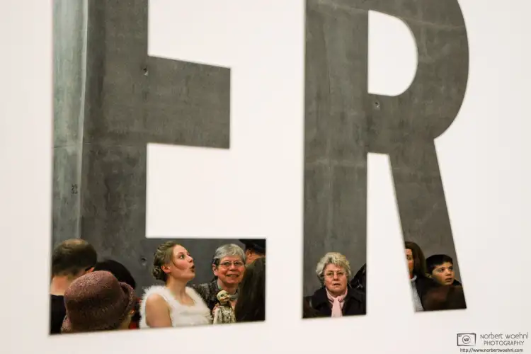 A puppet player performs in front of an installation of glass letters at the Kunstmuseum in Stuttgart, Germany.