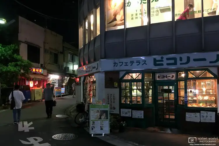 Evening shot of a cafe outside of Itabashi Station in Tokyo, Japan, with a massage salon on the upper floor.