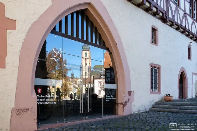 The spire of Stadtkirche (City Church) St. Martin is reflected off the entrance to a museum in Tauberbischofsheim, Germany.