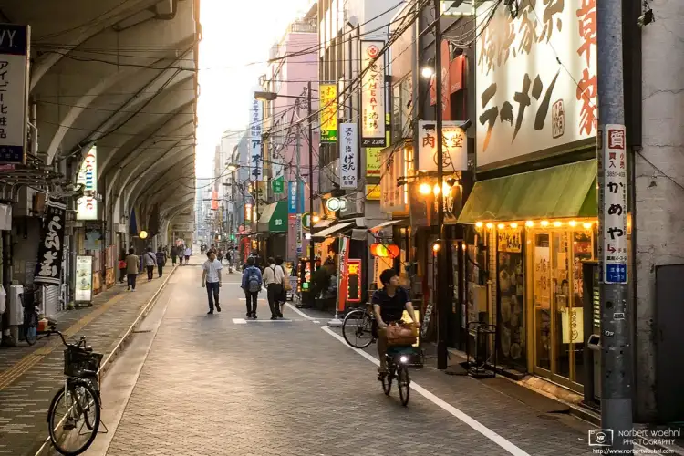 Late-afternoon passersby checking out Ramen restaurants in the Asakusabashi area of Tokyo, Japan.