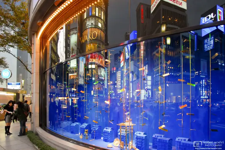 A blue-hour reflection off the curved corner window of Wako Department Store in the Ginza district of Tokyo, Japan.