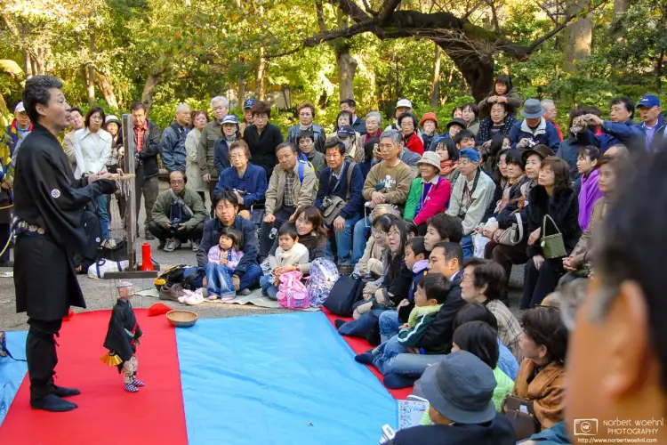 Visitors are watching the performance of a puppet player at Rikugien, a park in the northern center of Tokyo, Japan.