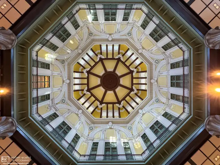 An upward view looking at the architectural details of the northern dome in the Marunouchi Building of Tokyo Station in Tokyo, Japan.