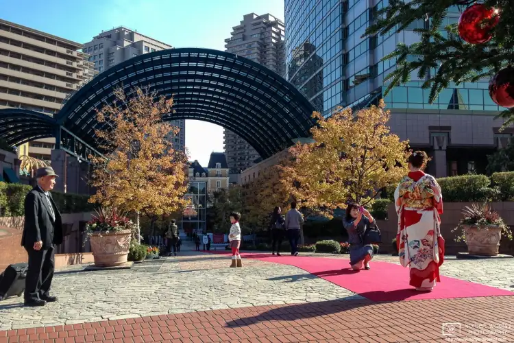 At Yebisu Garden Place in Ebisu, Tokyo, Japan, a woman in kimono is being photographed against a Christmas tree.