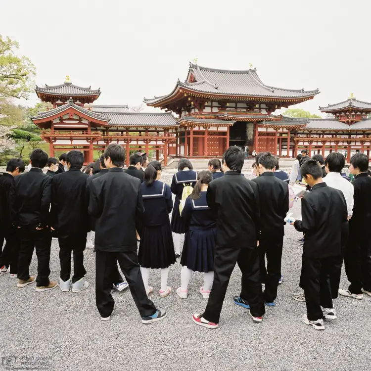 A group of high school students is seen outside Phoenix Hall at Byōdōin Temple in Uji, Japan.